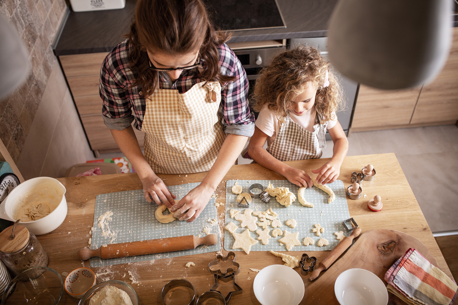 Mother and daughter playing and preparing dough in the kitchen.